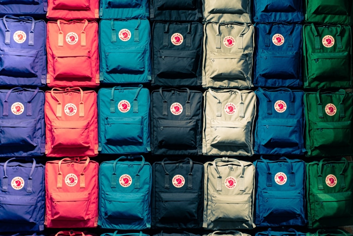 Fotografía de producto de varias mochilas alineadas y organizadas por color.