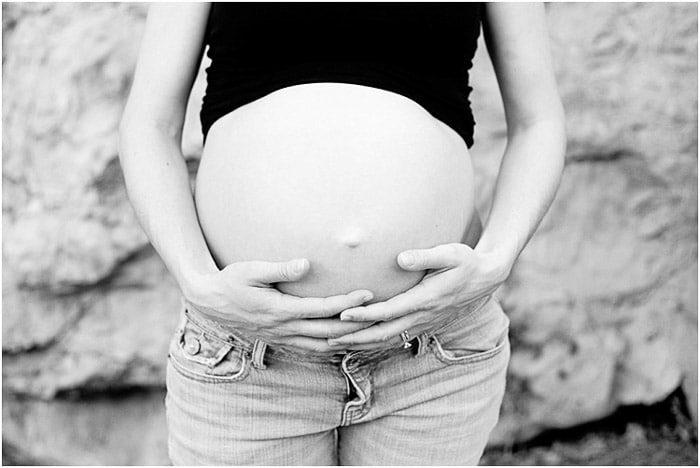 Retrato en blanco y negro de una mujer embarazada sosteniendo su vientre
