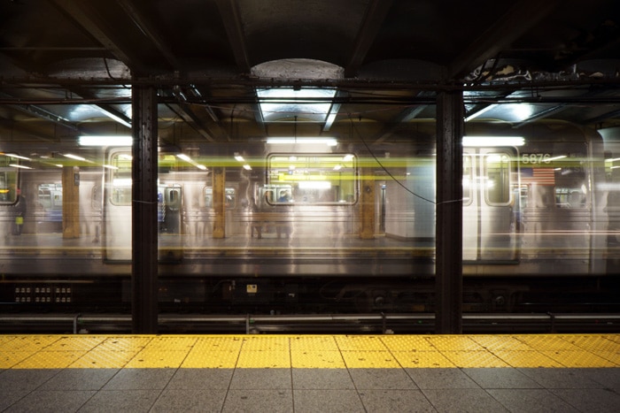 Foto atmosférica de larga exposición de un tren subterráneo que se mueve a través de una estación tomada con enfoque manual