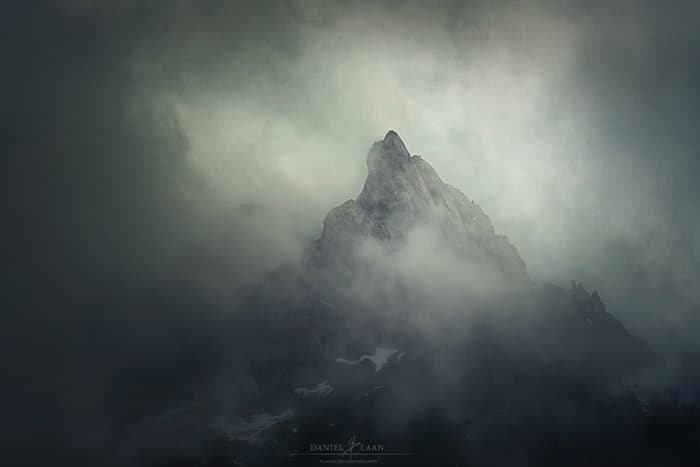 Tiro brumoso atmosférico de un pico solitario en las montañas suizas