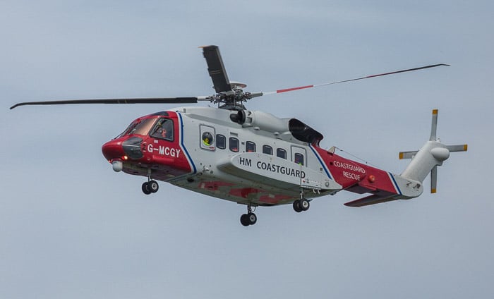 Un helicóptero en pleno vuelo, sus rotores se ven extrañamente estáticos debido a la fotografía de movimiento borroso