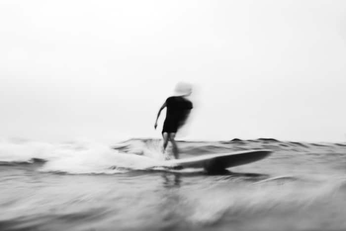 Foto borrosa de movimiento de un hombre surfeando