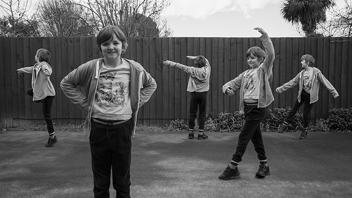Un ejemplo de fotografía de multiplicidad de gran angular en blanco y negro de cinco de la misma niña bailando al aire libre