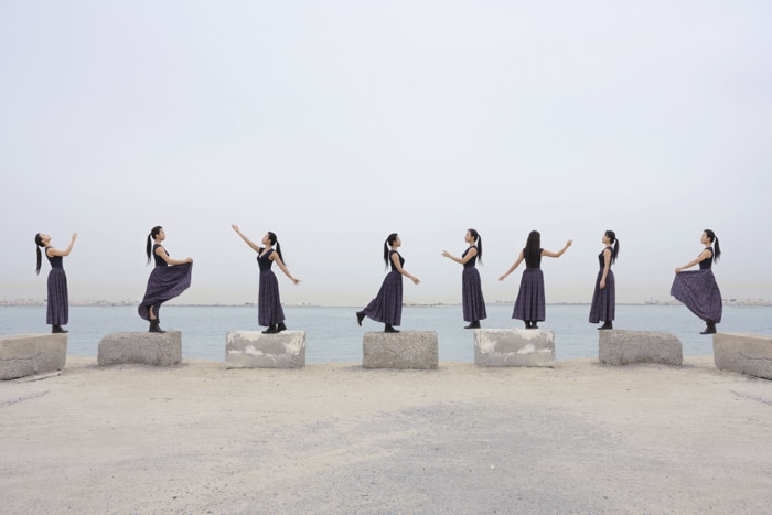 Una foto multiplicidad de una mujer clonada bailando alrededor de una playa