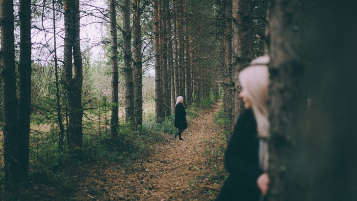 Una mujer clonada caminando en un bosque
