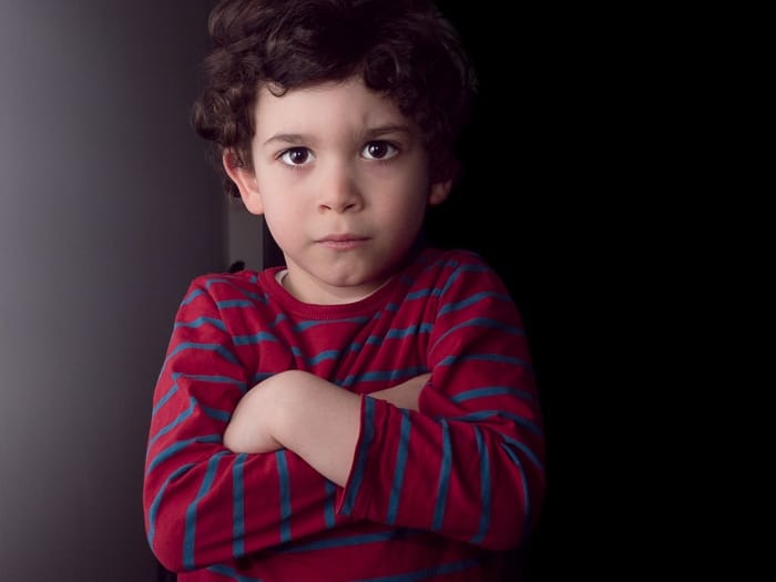 Retrato de un niño tomado con el flash de la cámara rebotado en una pared blanca