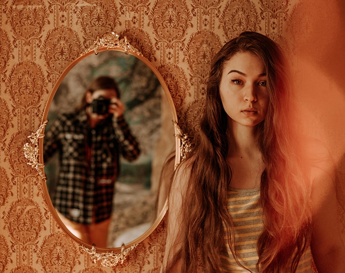 Un retrato díptico de una modelo femenina morena con el fotógrafo reflejado en un espejo