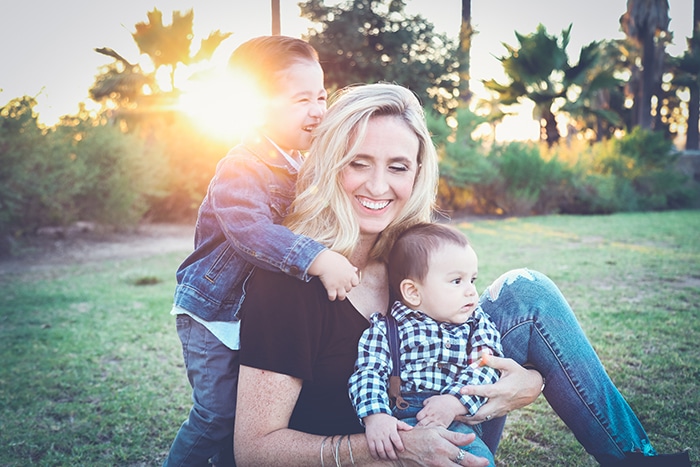 una dulce mami y yo sesión de fotos de una madre y dos hijos pequeños jugando al aire libre