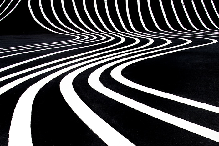 una foto abstracta de alto contraste de líneas blancas onduladas sobre un fondo negro
