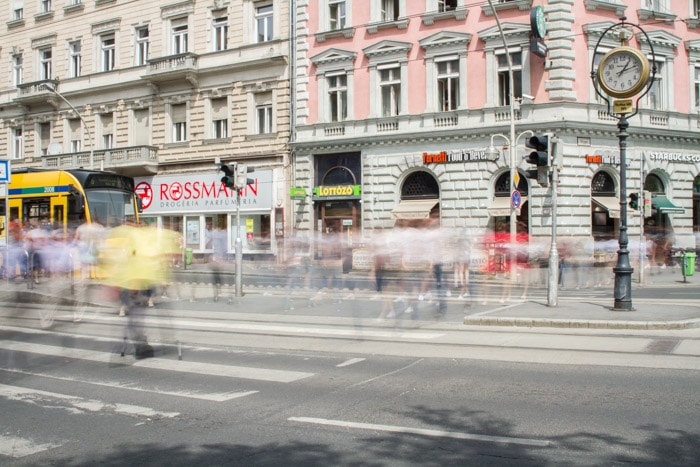 Larga exposición de peatones cruzando la calle en Oktogon, Budapest