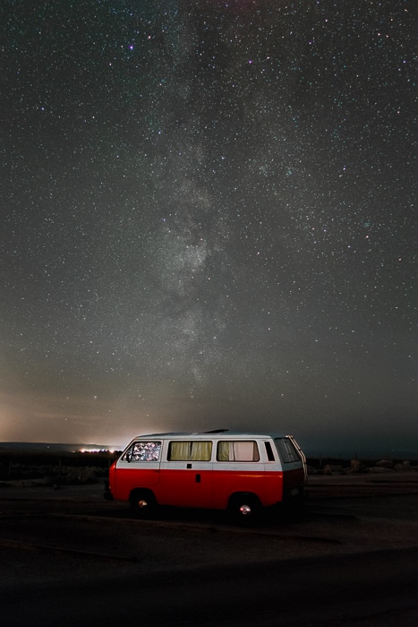 Una furgoneta roja bajo un cielo lleno de estrellas