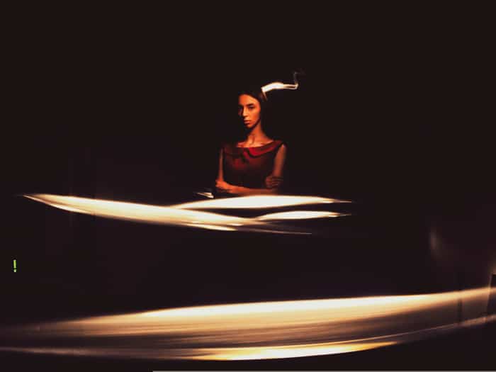 Un modelo femenino posando en una habitación oscura.