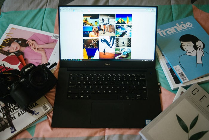Una naturaleza muerta de una computadora portátil en una cama con diferentes revistas esparcidas
