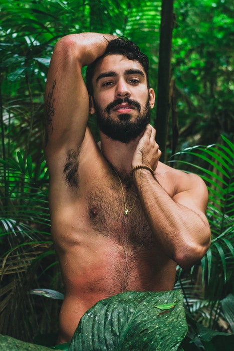 Foto de tocador de un modelo masculino semidesnudo en un entorno exótico