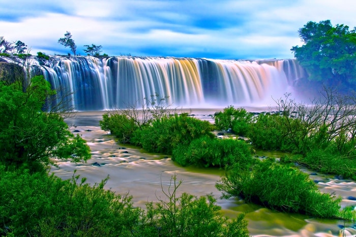 imagen de larga exposición de cascadas que fluyen en un lago