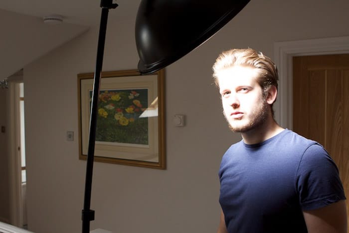 Un modelo masculino posando para una foto, con una configuración de iluminación de bajo perfil