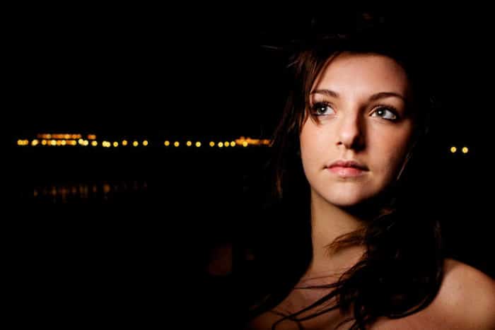 Retrato atmosférico de bajo perfil de una modelo femenina en la noche