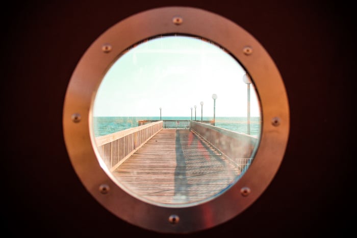 Vista de un muelle a través de un ojo de buey de barco