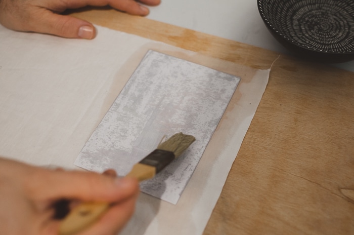 Aplicar agua sobre papel con brsuh