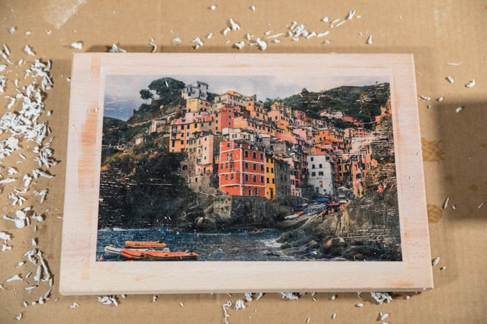 La imagen final: foto colorida de la ciudad costera transferida a una tabla de madera