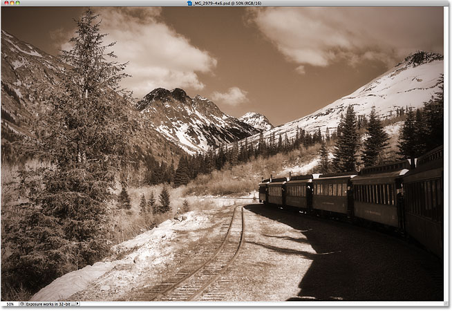 Una foto en tonos sepia de un tren que se dirige a las montañas.