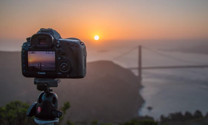 Una cámara DSLR instalada en un trípode Manfrotto para capturar una hermosa puesta de sol