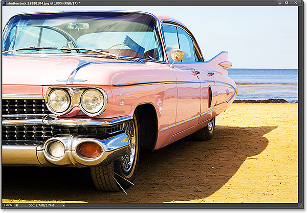 Coche rosa clásico en la playa.  Foto con licencia de Shutterstock de Photoshop Essentials.com