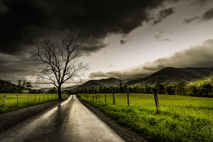 Clima dramático: cielo oscuro sobre campos y una carretera después de una tormenta
