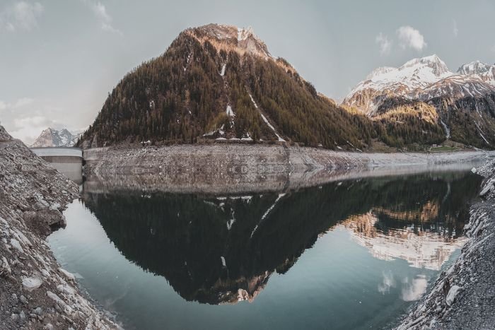 Foto de una montaña reflejándose en un paisaje acuático