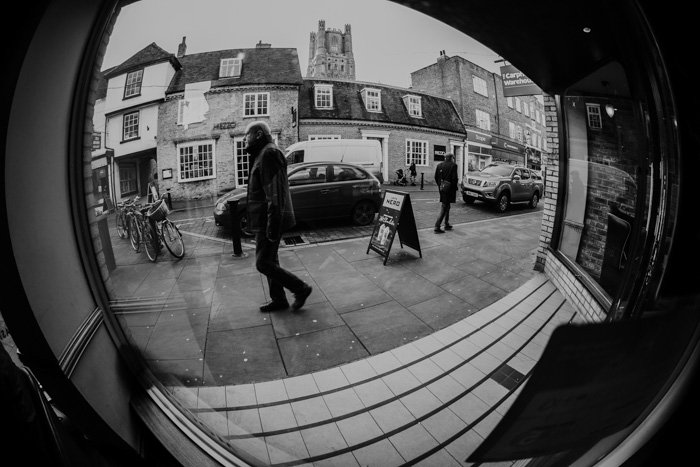 Una imagen en blanco y negro de una escena callejera, tomada con una distancia focal ultra gran angular