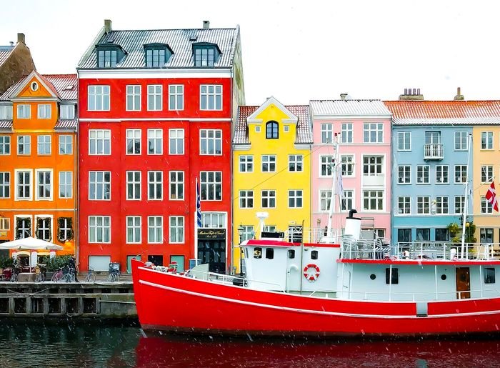 Foto de un barco con casas de colores en el fondo