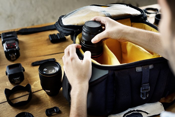 Una persona que organiza su bolsa de cámara de fotografía de viaje.