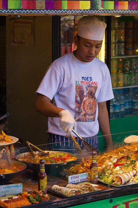 Hombre preparando comida mexicana en un puesto de comida en Camden Market.