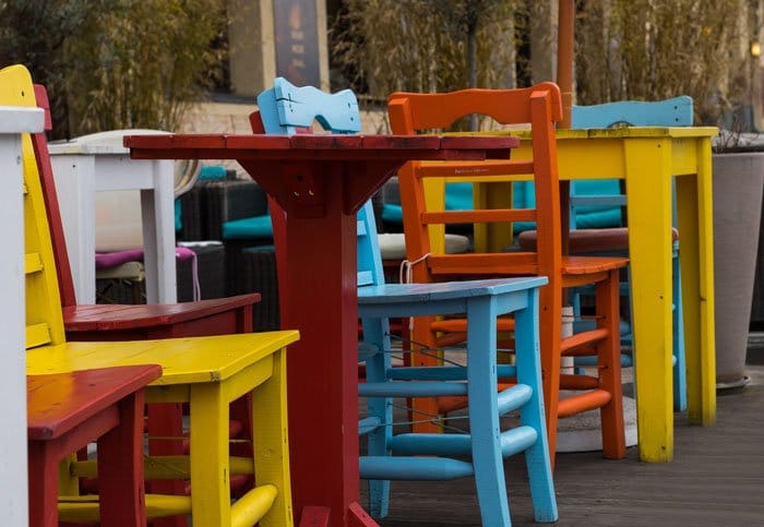 Coloridos cafés al aire libre y sillas con colores triádicos