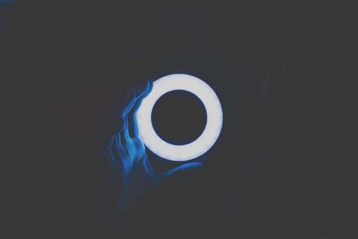 Una persona sosteniendo un anillo de luz en una habitación oscura.