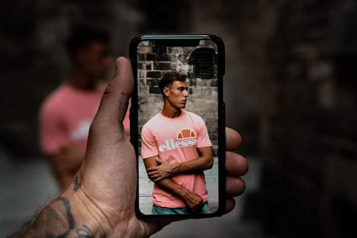 una persona tomando un retrato callejero con la cámara de un teléfono inteligente