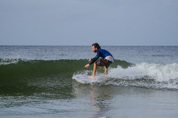 Un hombre surfeando con un teleobjetivo.