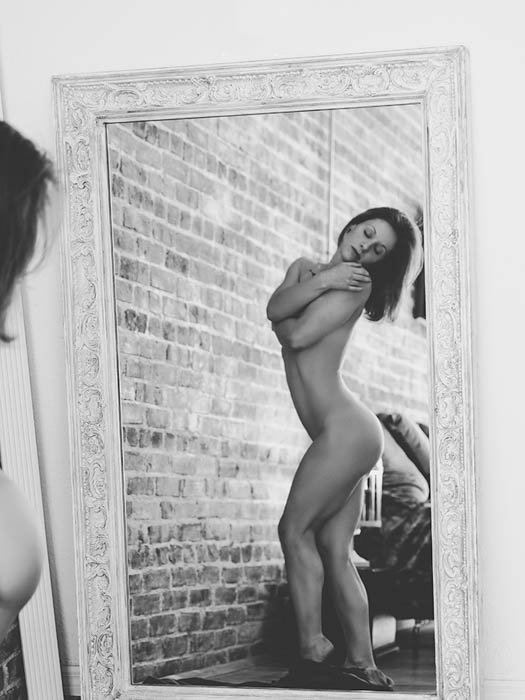 Sensual retrato en blanco y negro de una mujer posando frente a un espejo
