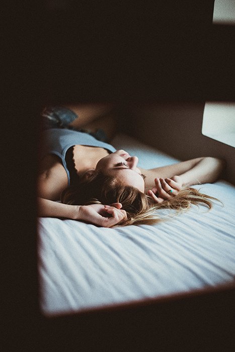 Una foto sincera de una mujer posando en una cama