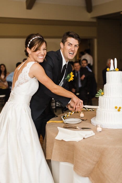 Divertido retrato de boda de los recién casados ​​cortando el pastel.