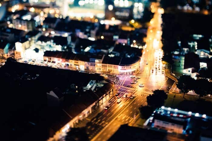 Un paisaje urbano en expansión por la noche, fotografiado desde arriba con una lente de fotografía tilt-shift
