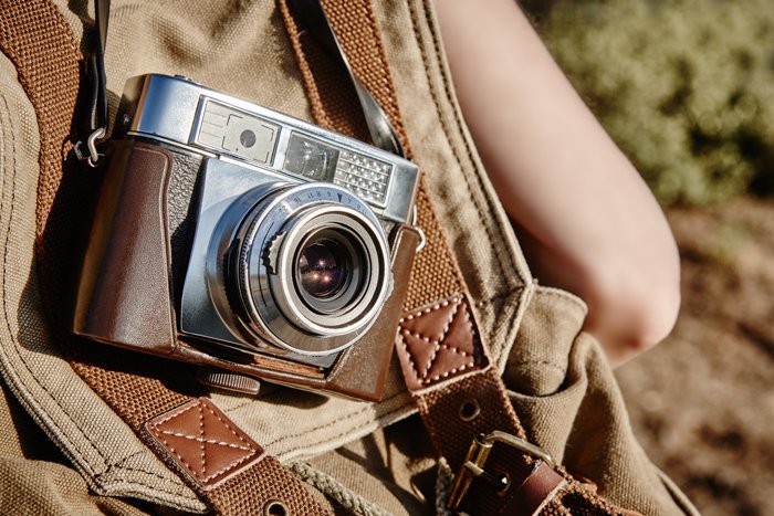 Una imagen de una cámara vintage en una mochila de cuero.
