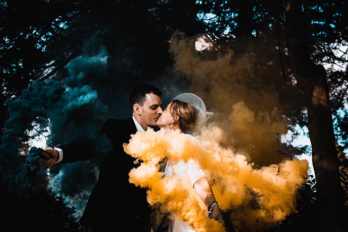 Una pareja posando con bombas de humo.