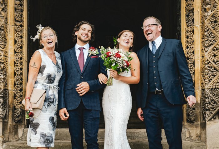 una imagen de la novia, el novio y los miembros de la familia celebrando su boda