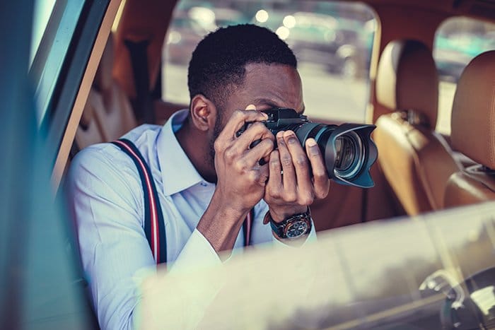 Fotógrafo disparando desde un coche con una cámara réflex digital.