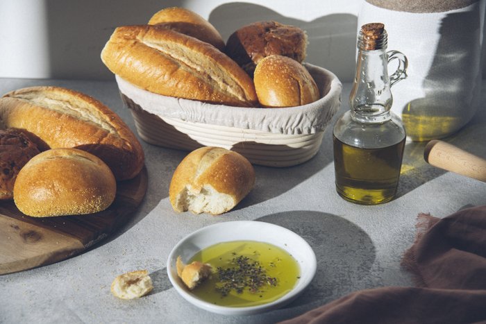 Un hermoso bodegón de alimentos de cestas rústicas de pan y aceite de oliva