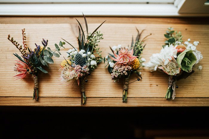 Bodegón de cuatro ramos de flores de boda sobre una superficie de madera