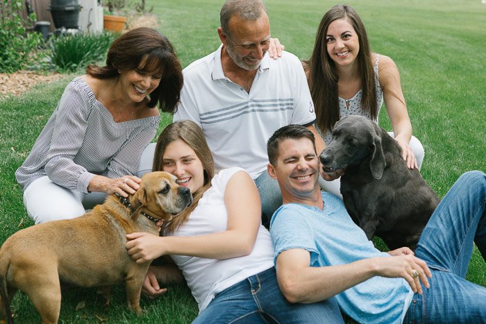 Una familia de cinco personas posando casualmente al aire libre con perros: el momento decisivo en la fotografía