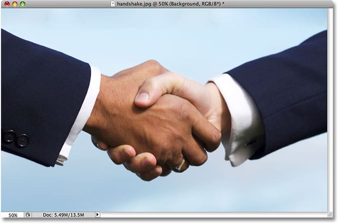 Dos hombres de negocios dándose la mano.  Imagen con licencia de iStockphoto de Photoshop Essentials.com