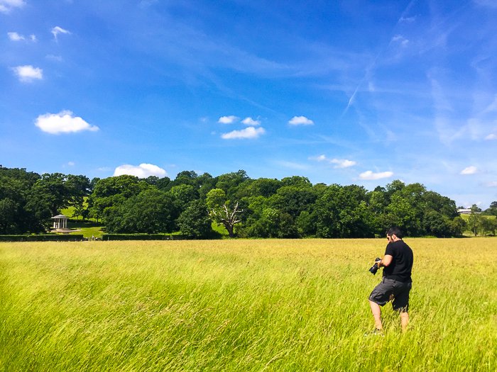 Un fotógrafo comprobando la configuración de su cámara en un hermoso paisaje rural de un día claro